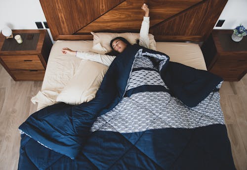 Woman in Black and White Dress Lying on Bed