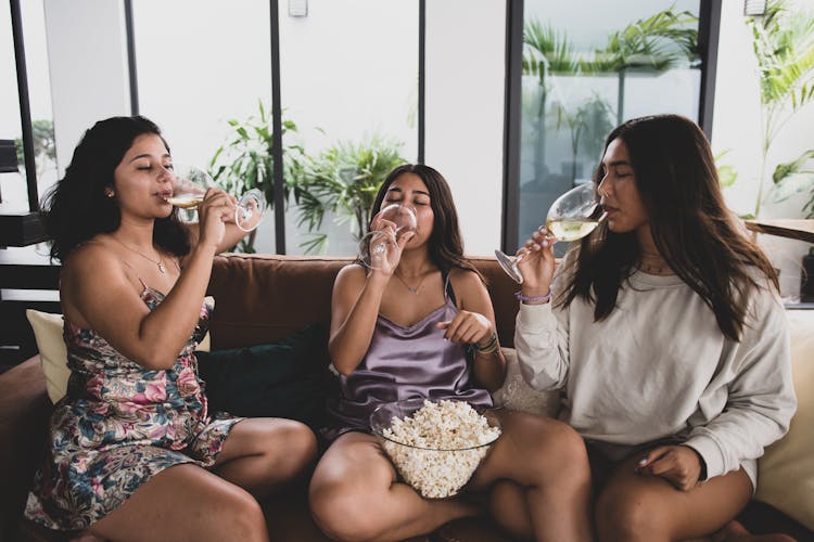 A Group Of Friends Drinking Wine While Sitting On The Couch