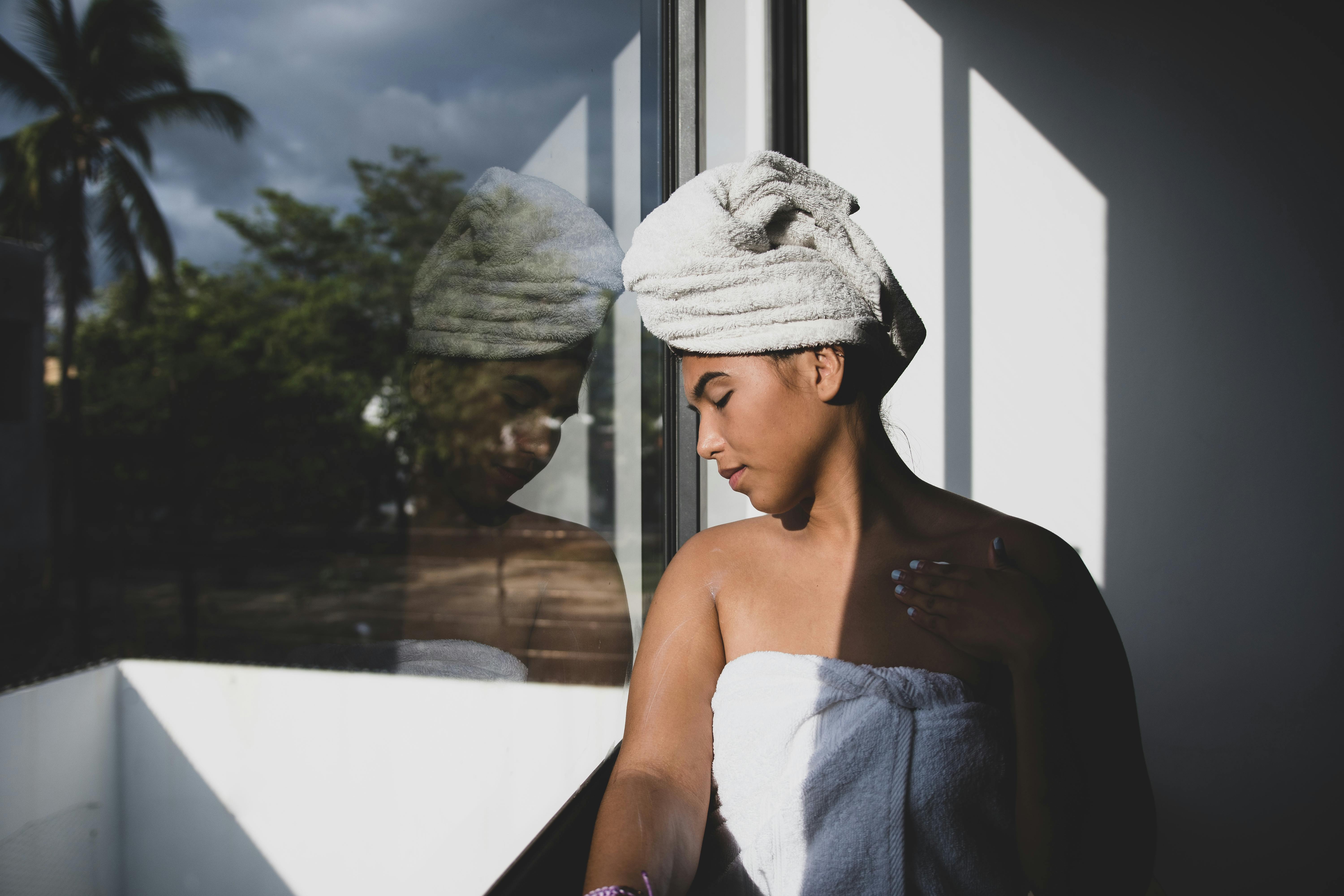 a woman s head leaning on a glass window