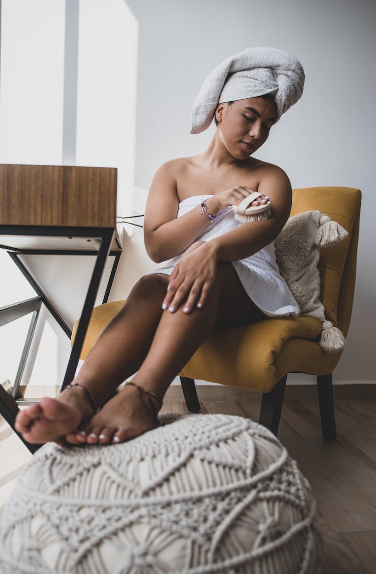 Woman Wrapped In Towel Brushing Her Skin 