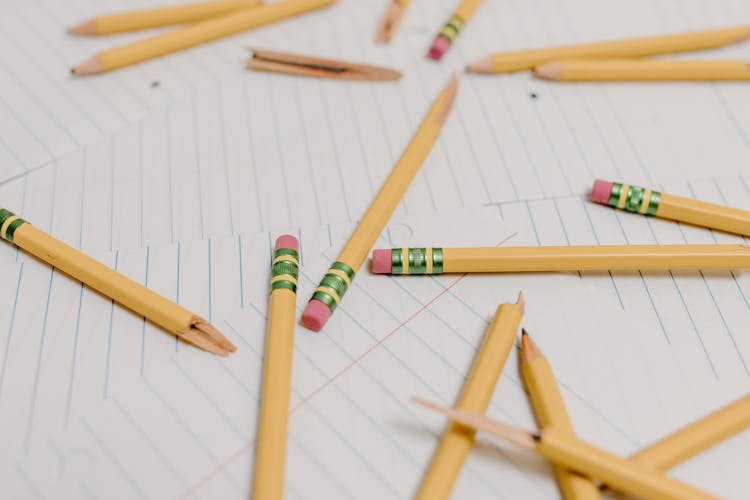 Close-Up Photo Of Broken Pencils On White Paper