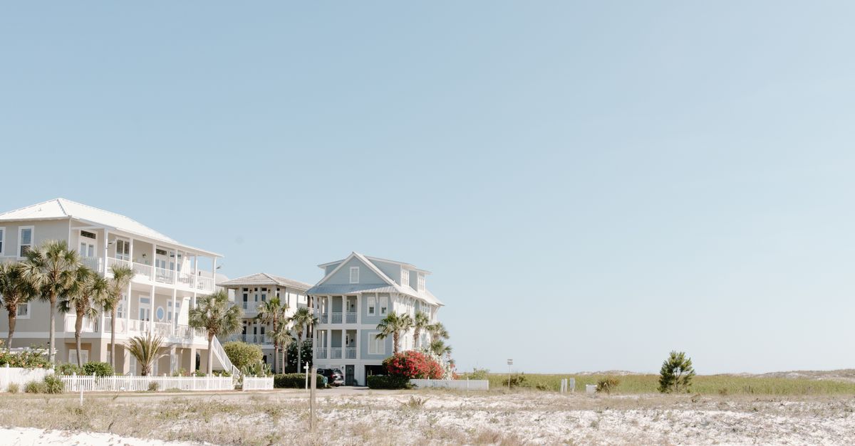 Beachfront homes with a clear sky, showcasing serene architecture and coastal beauty.
