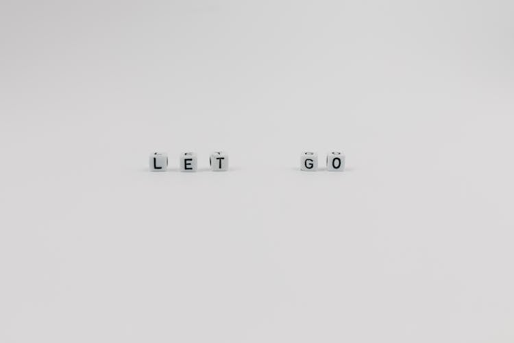 A Let Go Slogan Spelled With Letter Dice On White Background