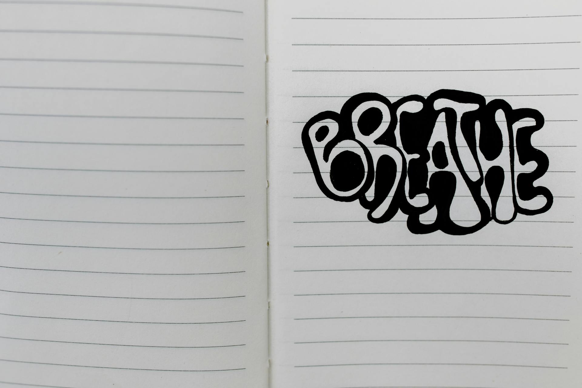 Handwritten word 'breathe' in bold letters on open lined notebook paper for motivation.