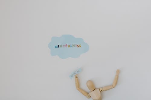 Wooden Figure and Mindfulness Word on White Background