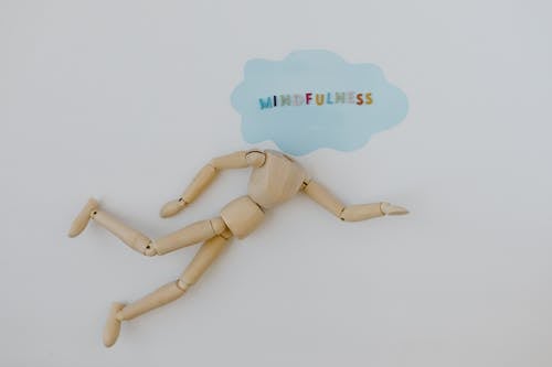 Wooden Figure with Mindfulness Word in Speech Bubble