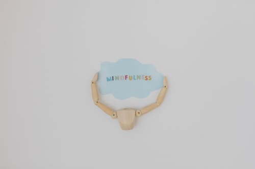 Wooden Figure Holding Speech Bubble with Mindfulness Word