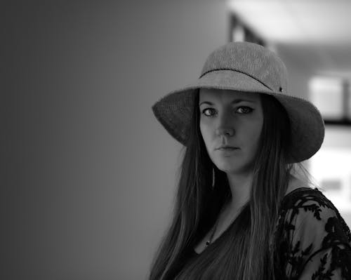 Free Grayscale Photo of a Woman with a Hat Looking at the Camera Stock Photo