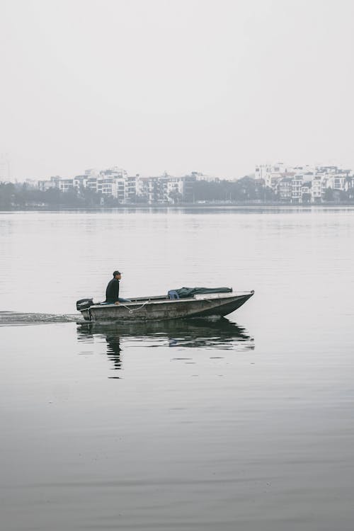 Man Riding on Boat on Body of Water