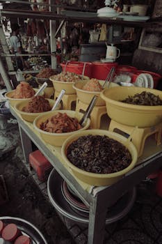 Colorful variety of spices in bowls at a local Vietnamese market stall, showcasing traditional flavors.