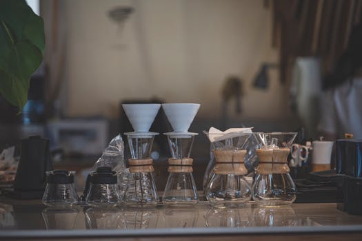 A detailed view of Chemex coffee makers and accessories arranged on a cafe countertop.
