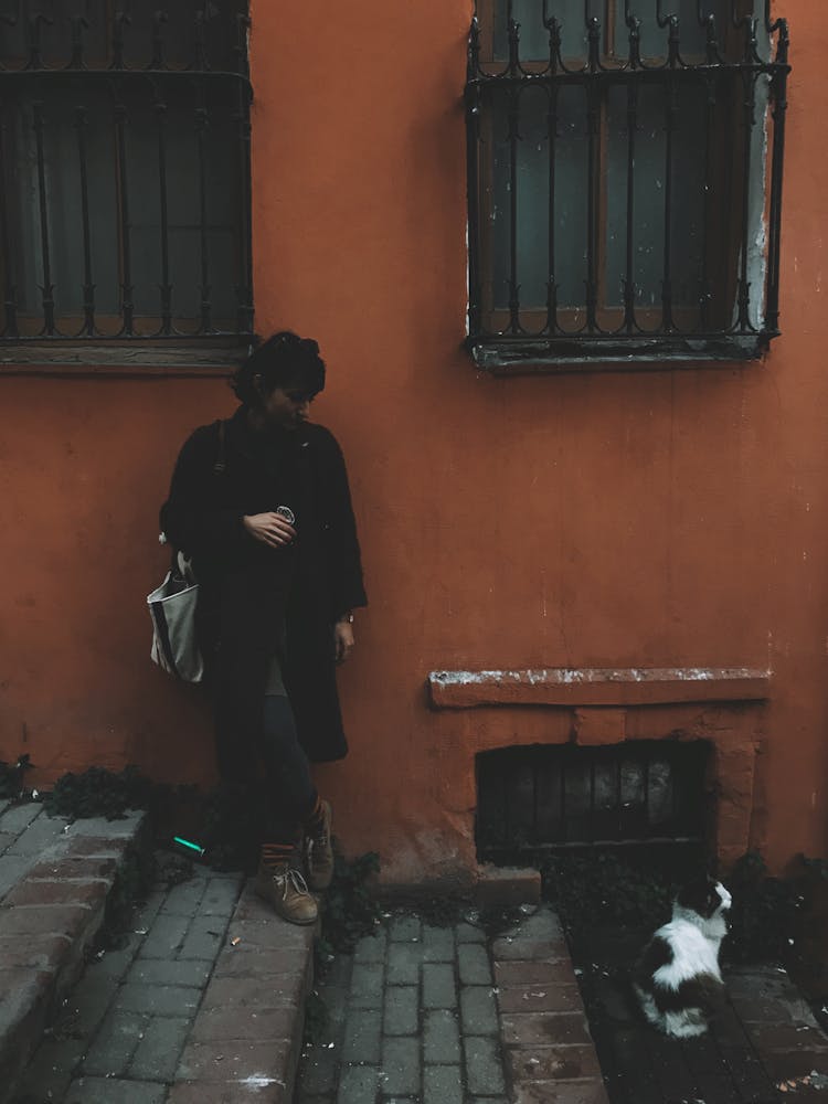 Woman Standing On The Stairs Beside A Cat