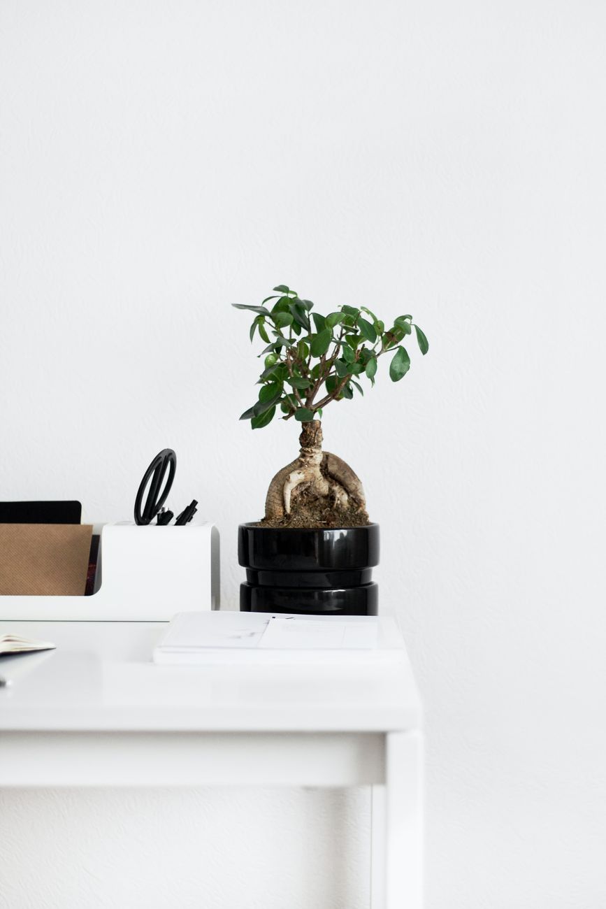 Small desk organized with a laptop and simple supplies