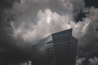 Photograph of a High-Rise Building Under White Clouds