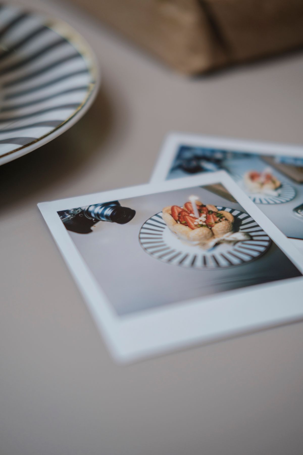 Small printed photos on a table beside a place setting