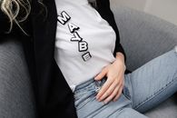 Photo of a Woman Wearing a White Shirt with the Letters Forming the Word Maybe