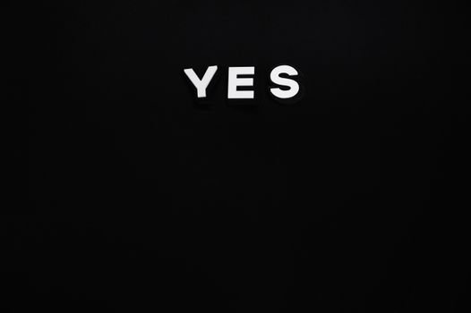 Bold white 'YES' letters on a minimalist black background, conveying positivity and affirmation.