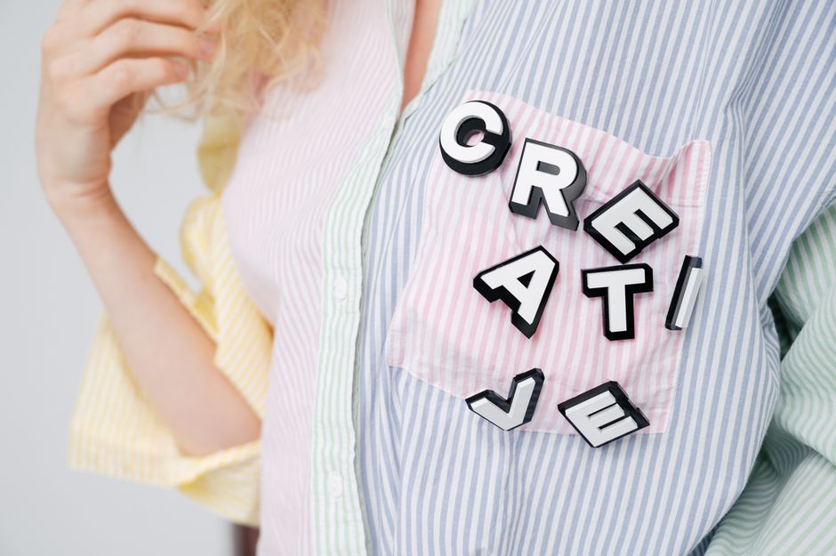 Close-up of the word 'Creative' on a pastel striped shirt pocket with 3D letters.