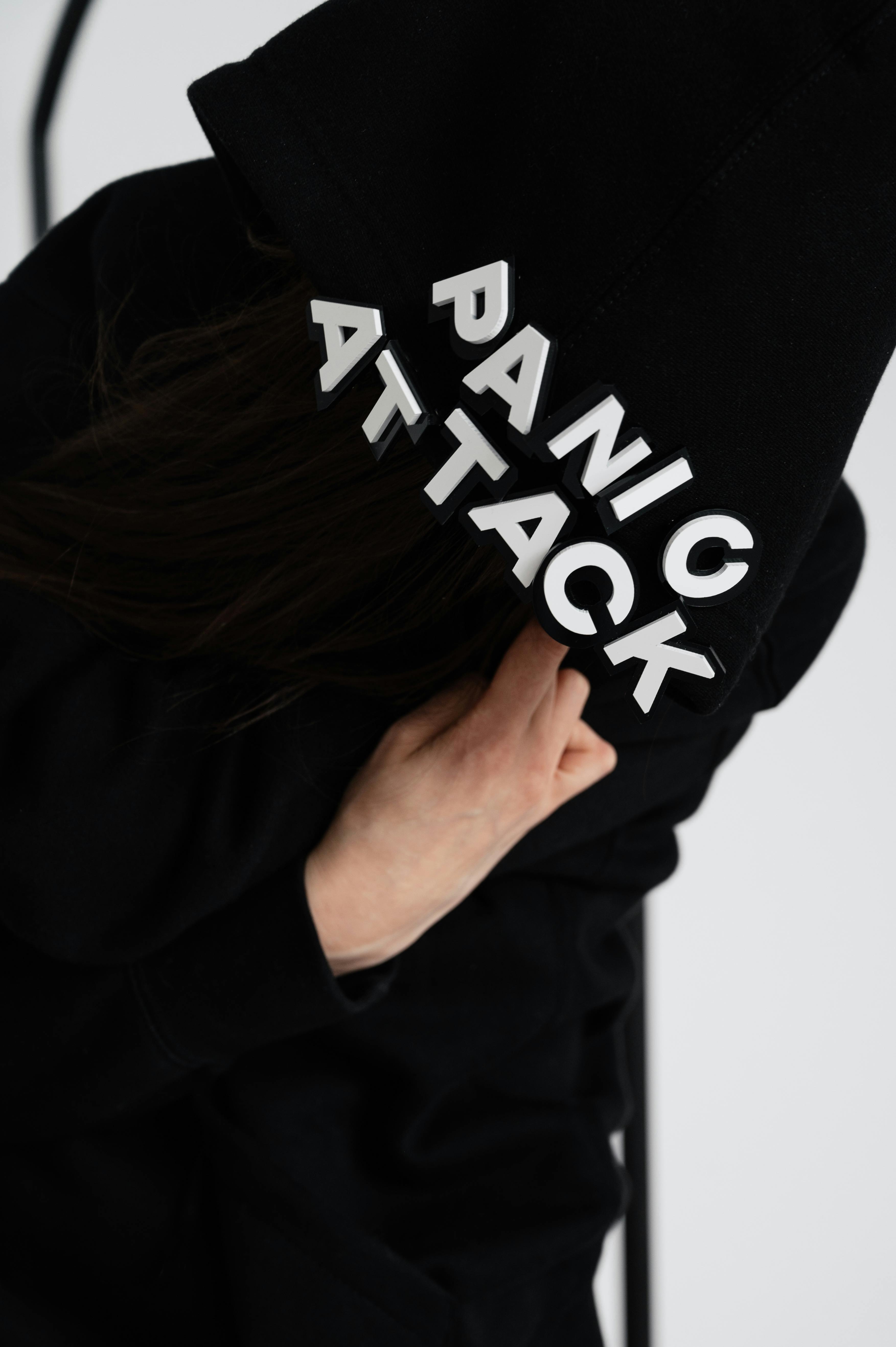 A creatively angled close-up of a black hoodie with 'Panic Attack' text, emphasizing mental health awareness.