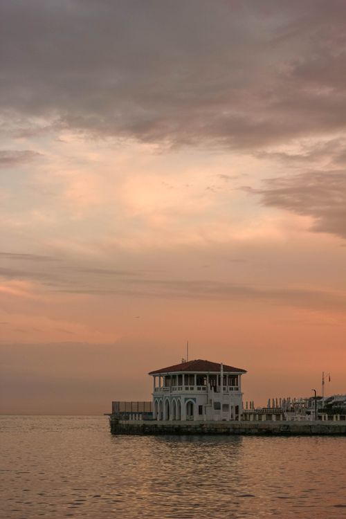 Free A tranquil sunset over the ocean with a dock and viewing deck, perfect for relaxation. Stock Photo
