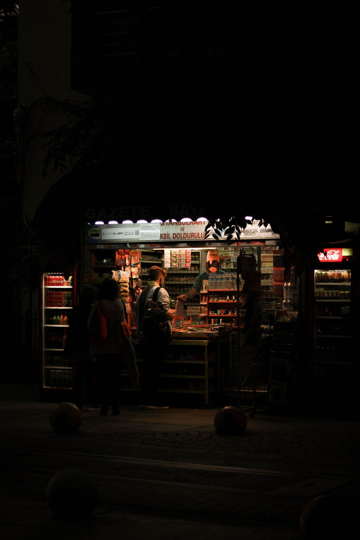 Interior de un kiosco con productos y clientes