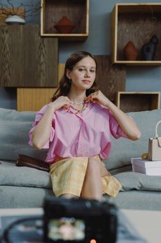 Woman in casual pink shirt relaxing on sofa with accessories.