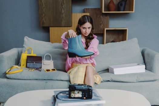 Young woman showcasing a stylish blue boot in an indoor setting.