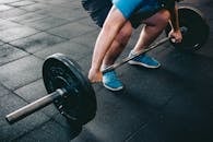 一名男子在室内举起哑铃，展现力量、健康与奉献精神