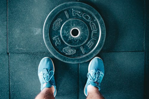 Black Steel Gym Plate and Pair of Blue Running Shoes