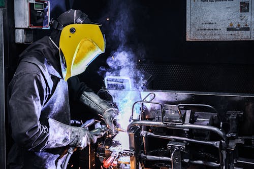 Person Wearing a Yellow Welding Helmet