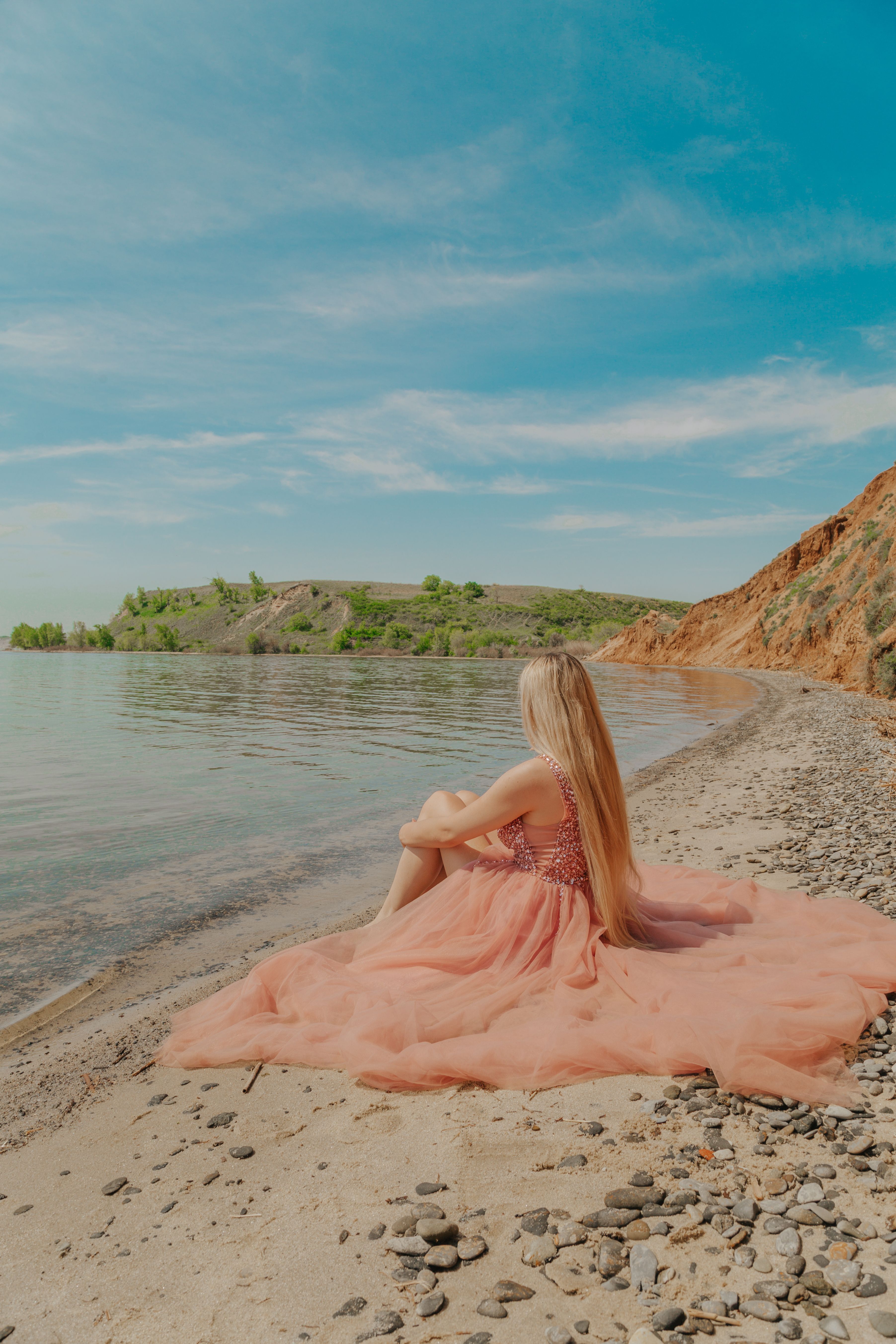 A Woman Wearing a Pink Dress Sitting on the Beach  Free Stock Photo
