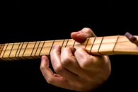 A Close-Up Shot of a Person Playing a Cigar Box Guitar
