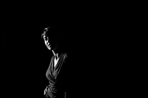 Free Moody black and white portrait highlighting dramatic shadow on a woman's face. Stock Photo