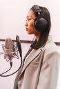 Woman in White Blazer Wearing Black Headphones