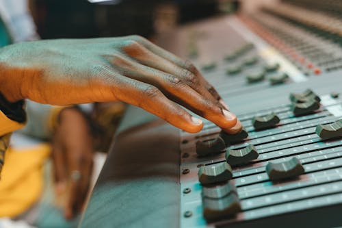 Person Using Control Panel in Music Studio