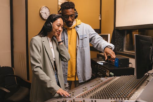 Woman and Man Standing in Front of Audio Mixer