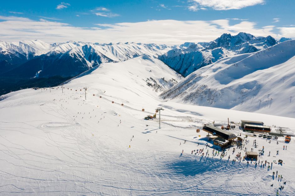 Breathtaking aerial shot of a ski resort with snowy mountains and skiers enjoying winter activities.