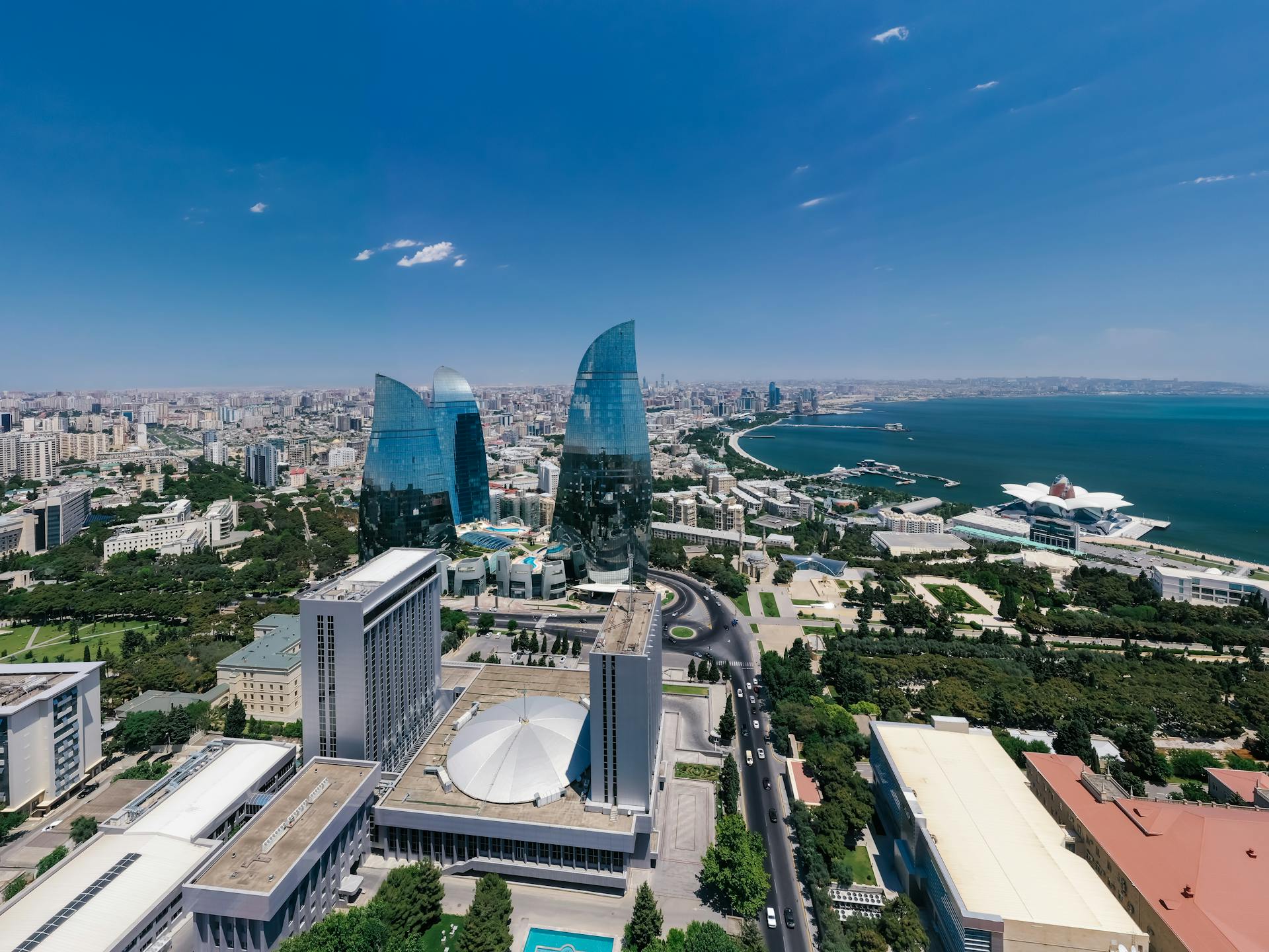 Vibrant aerial shot of Baku skyline featuring iconic Flame Towers and the Caspian Sea coast.