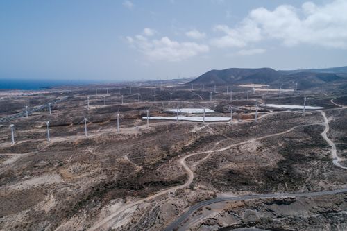 Free A stunning aerial view of a vast wind farm in a dry and arid landscape, showcasing renewable energy. Stock Photo