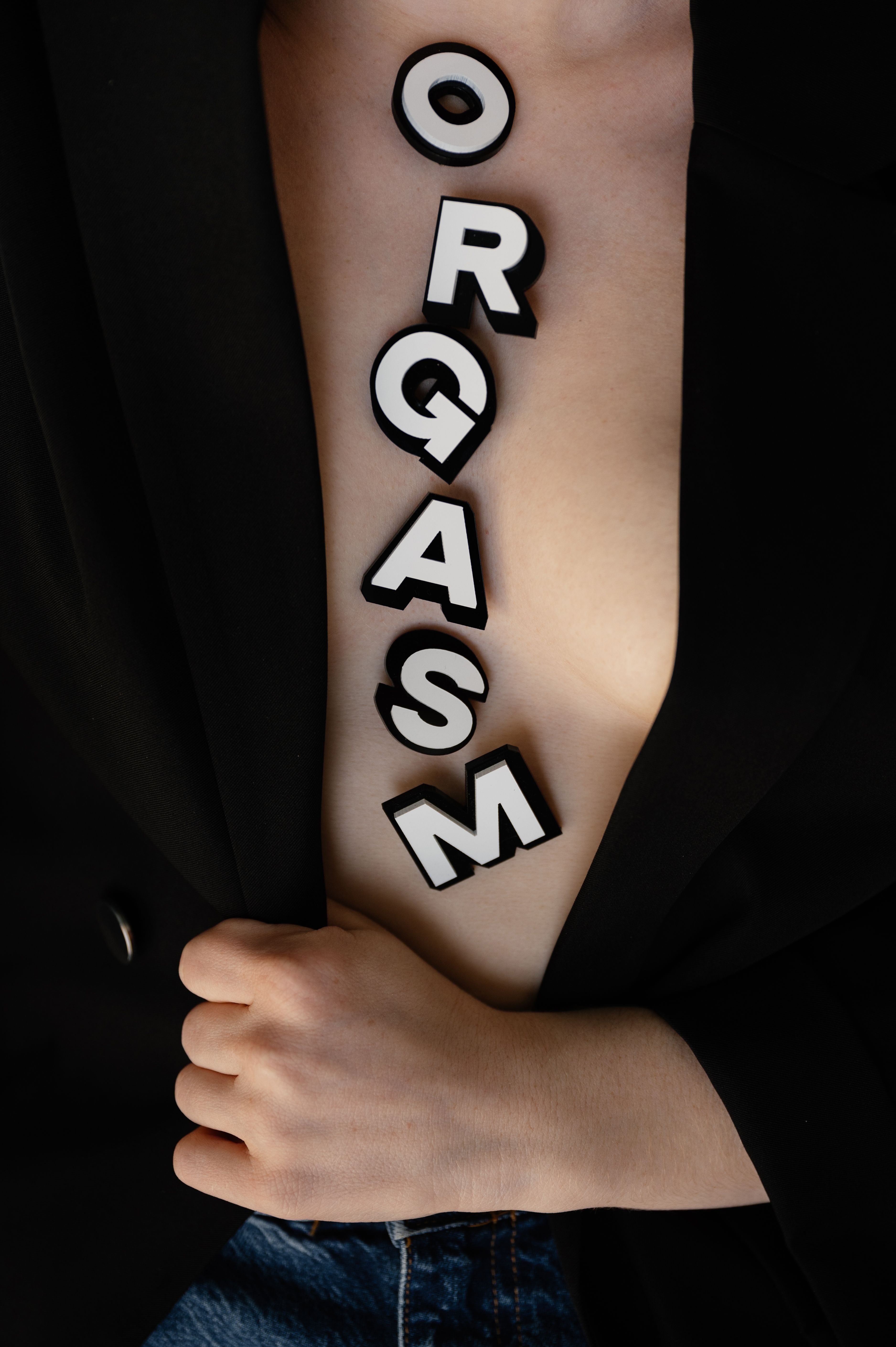 Close-up image of a person with bold letters on skin, featuring a creative typography display.