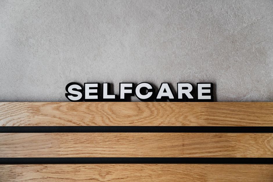 Inspirational 'Selfcare' text on a modern wooden and concrete background emphasizing wellness and lifestyle.
