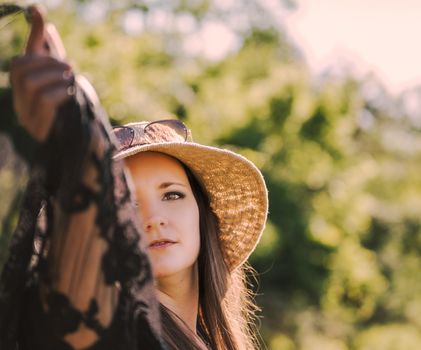 Captivating close-up of a woman wearing a sunhat outdoors, exuding summer vibes.