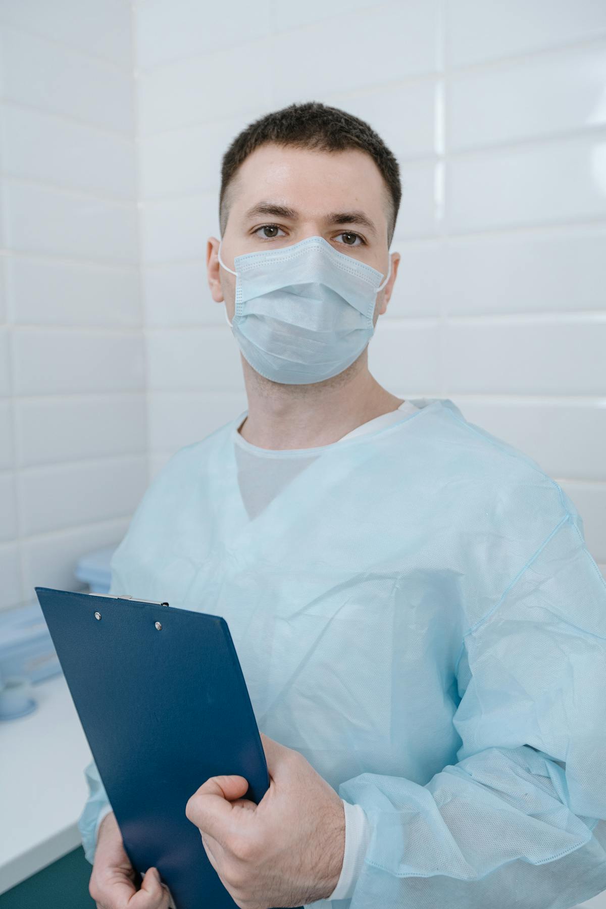 Person using hand sanitizer while wearing a mask in public