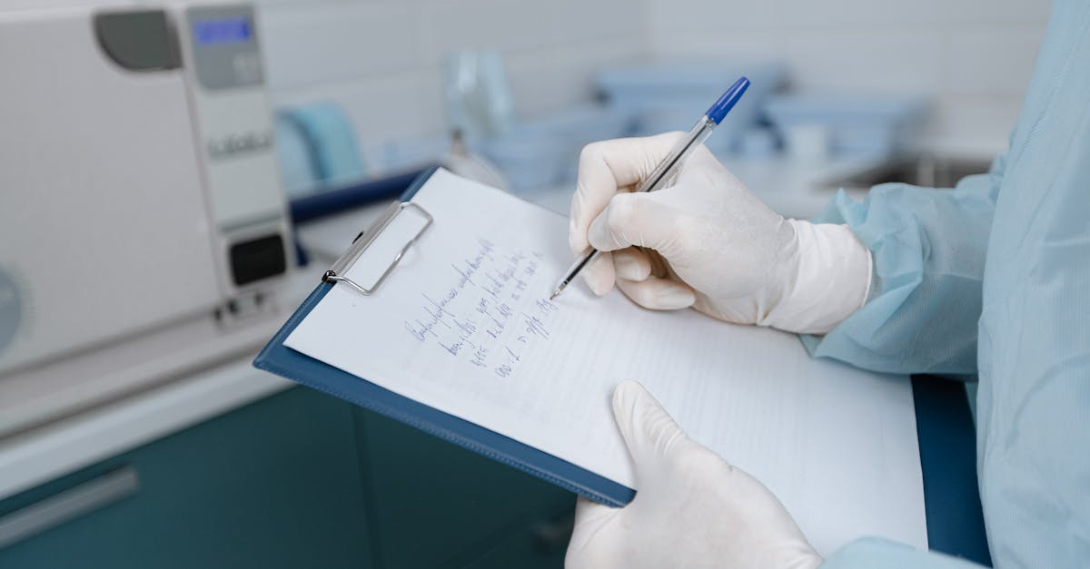 Medical worker in lab coat writing notes in a clinic setting.