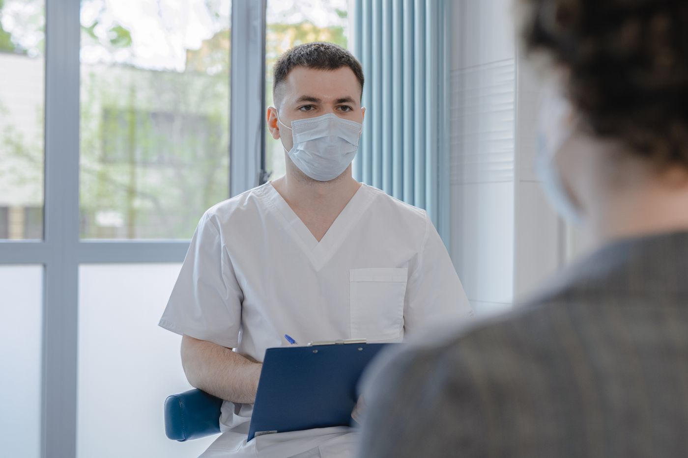 A healthcare professional listening attentively and taking notes during a private consultation