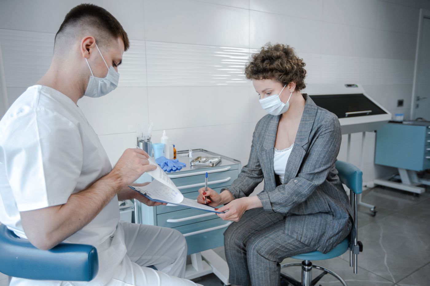 A doctor and patient wearing face masks during a consultation in a modern medical office. — illustrative stock photograph