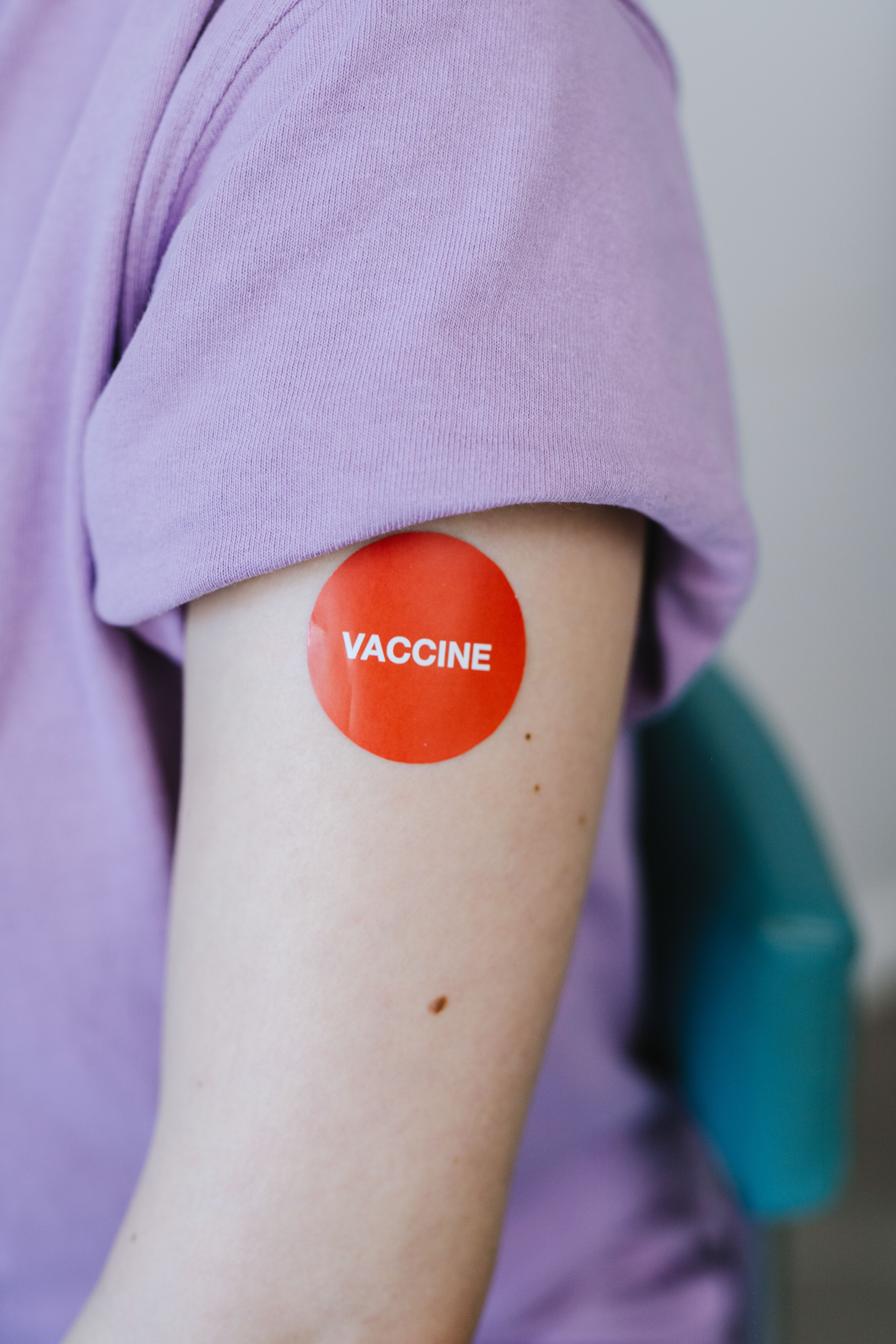 A person's arm with a red vaccine sticker, symbolizing vaccination.