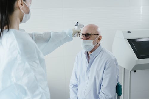 A Medical Professional Taking the Temperature of a Patient