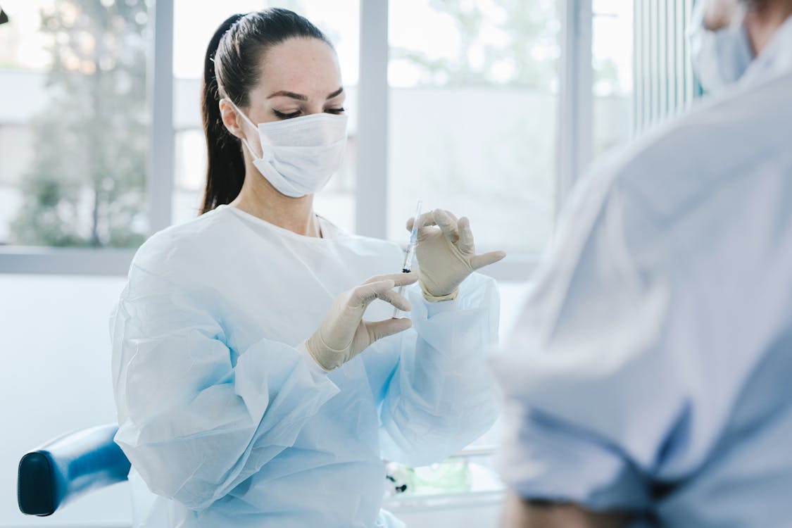 Free A Medical Professional Holding a Syringe Stock Photo