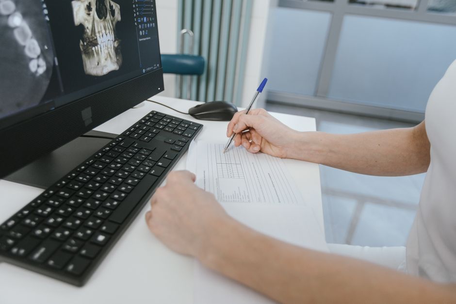 Dentist reviewing car tax paperwork in a UK dental practice office